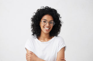 年轻的非裔美国妇女戴着眼镜微笑。